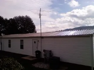 New metal roof on a single wide mobile home with a TV antenna in Bridgewater